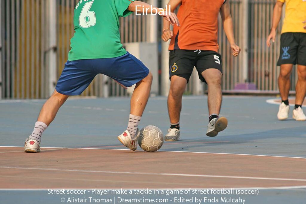 Street soccer -Player make a tackle in a game of street football (soccer)
